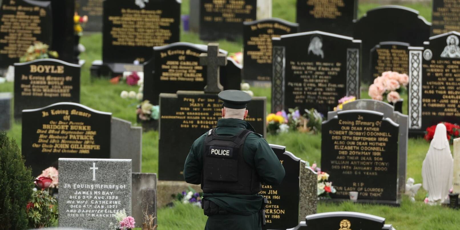 Ein PSNI-Polizist patrouilliert auf dem Stadtfriedhof von Londonderry. Kurz vor der Ankunft von US-Präsident Biden in Nordirland fand die Polizei dort vier mutmaßliche Rohrbomben.