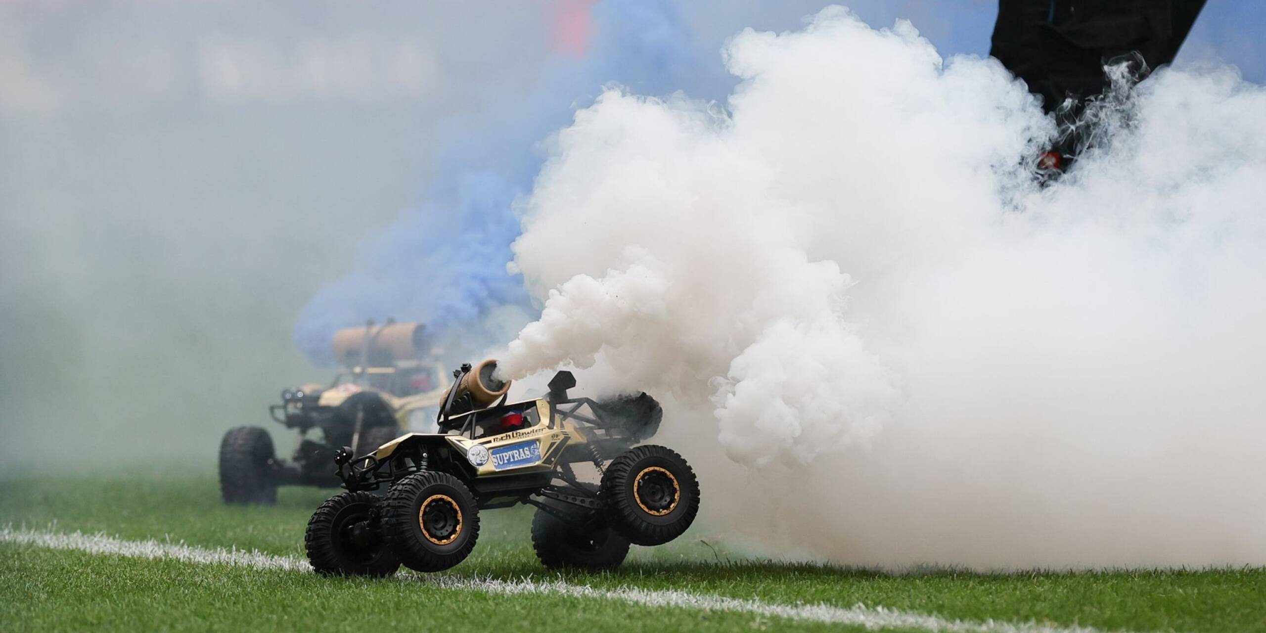 Aus Protest gegen den geplanten Investorendeal der Deutschen Fußball Liga haben Fans des FC Hansa Rostock ferngesteuerte Auto mit blau-weißen Rauchfackeln auf den Platz fahren lassen.