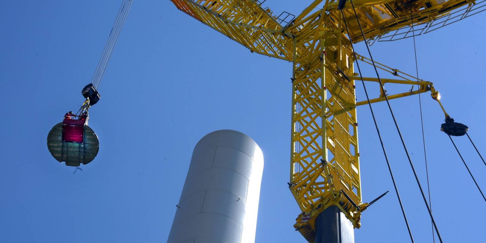 Im Windpark auf dem Gemeindegebiet von Sitten arbeiten Höhenmonteure am Stahlbetonturm einer im Bau befindlichen Windkraftanlage.