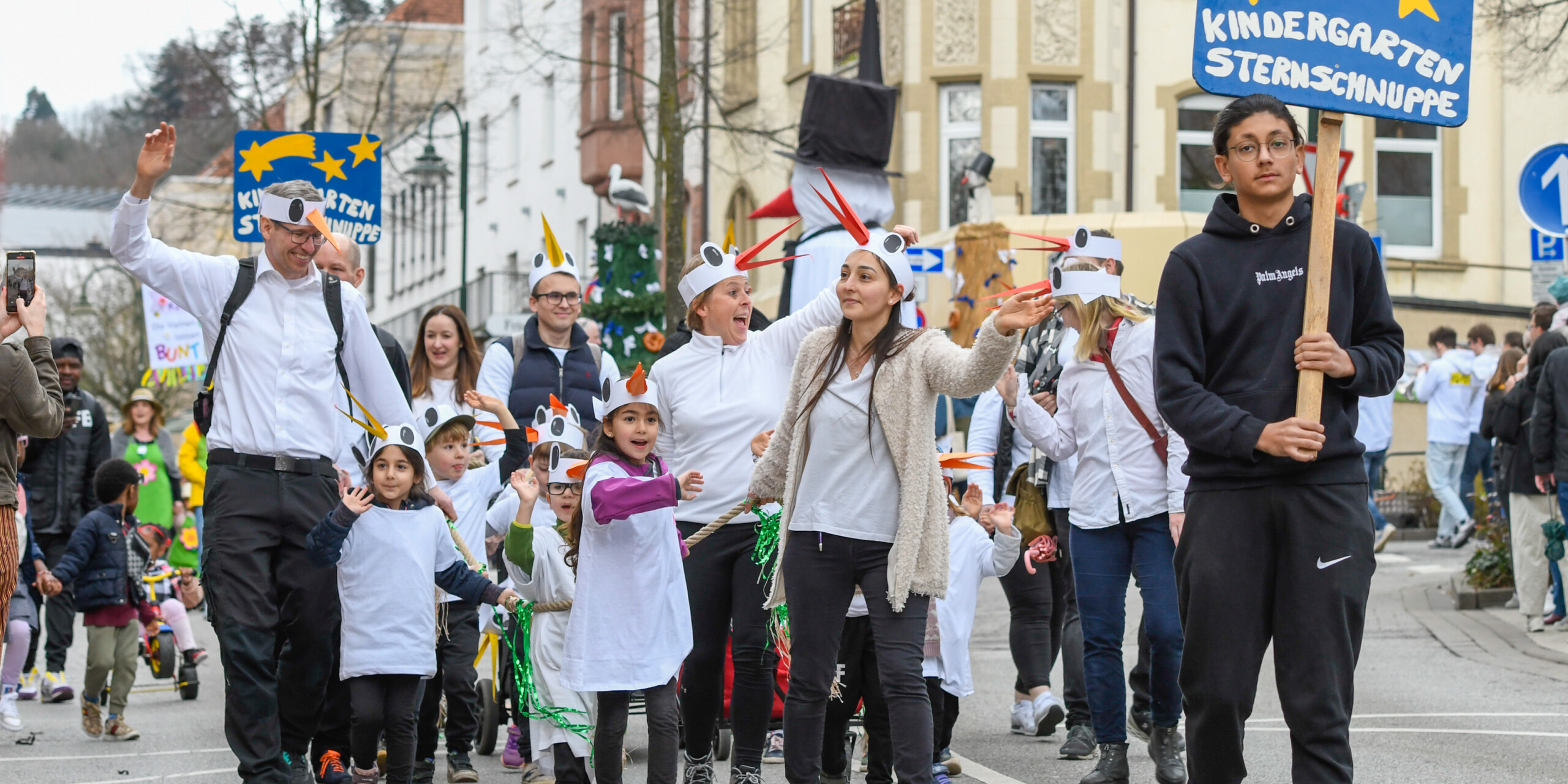 Kinder und Erwachsene des Kindergartens Sternschnuppe winken den Zuschauern fröhlich zu. Kinder und Erwachsene des Kindergartens Sternschnuppe winken den Zuschauern fröhlich zu.