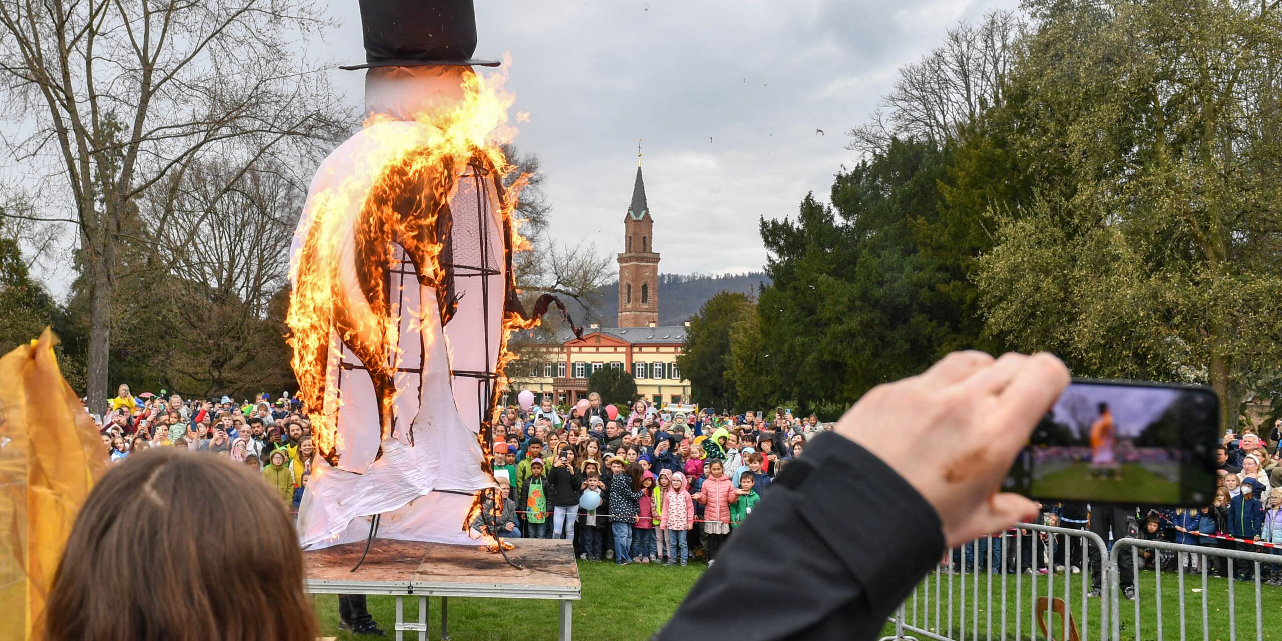 Na endlich: Der Schneemann geht im Schlosspark Weinheim in Flammen auf. Das wird natürlich mit dem Handy gefilmt und fotografiert.
