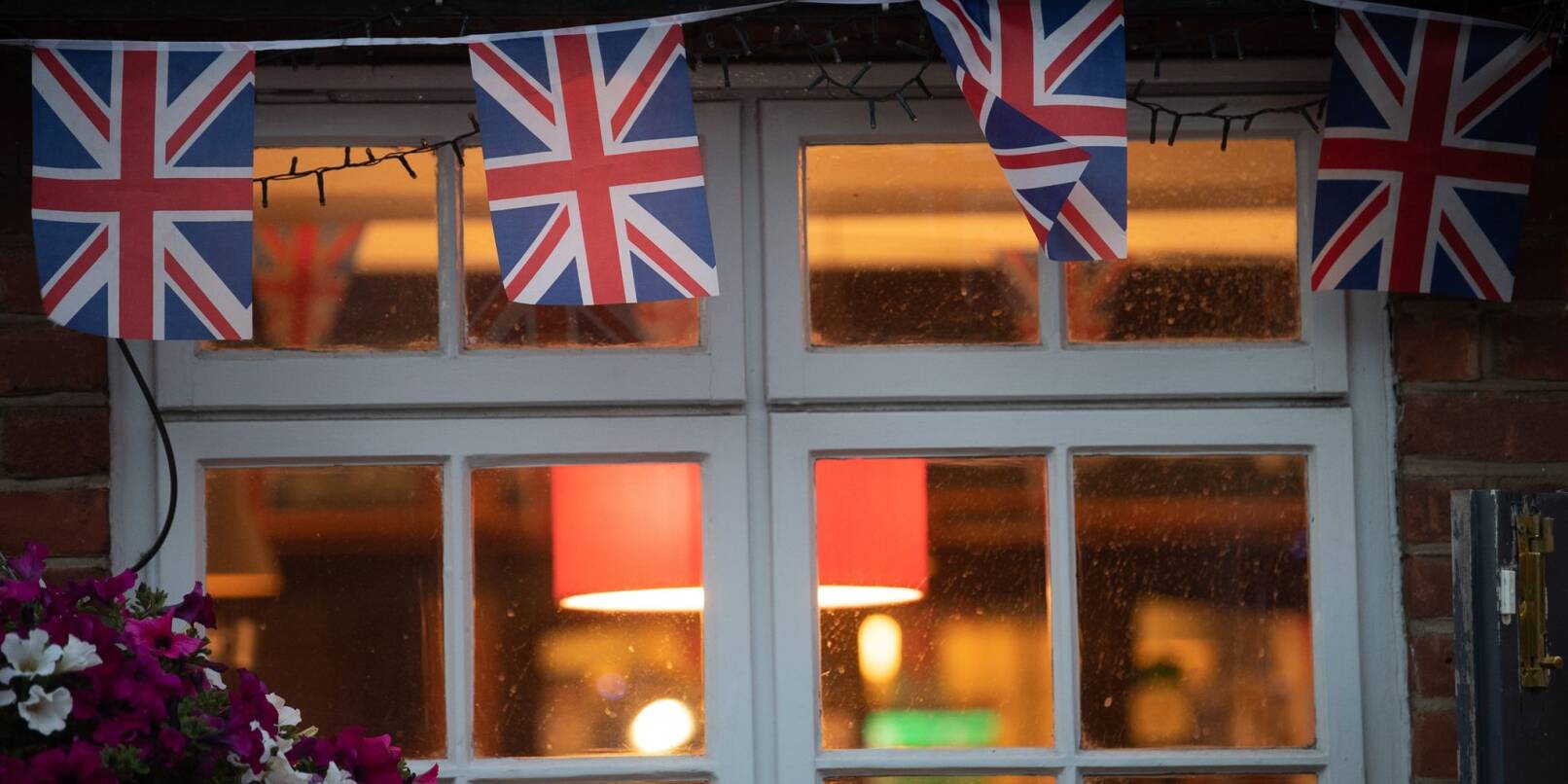 Union-Jack-Fahnen am Fenster eines Pubs in London.