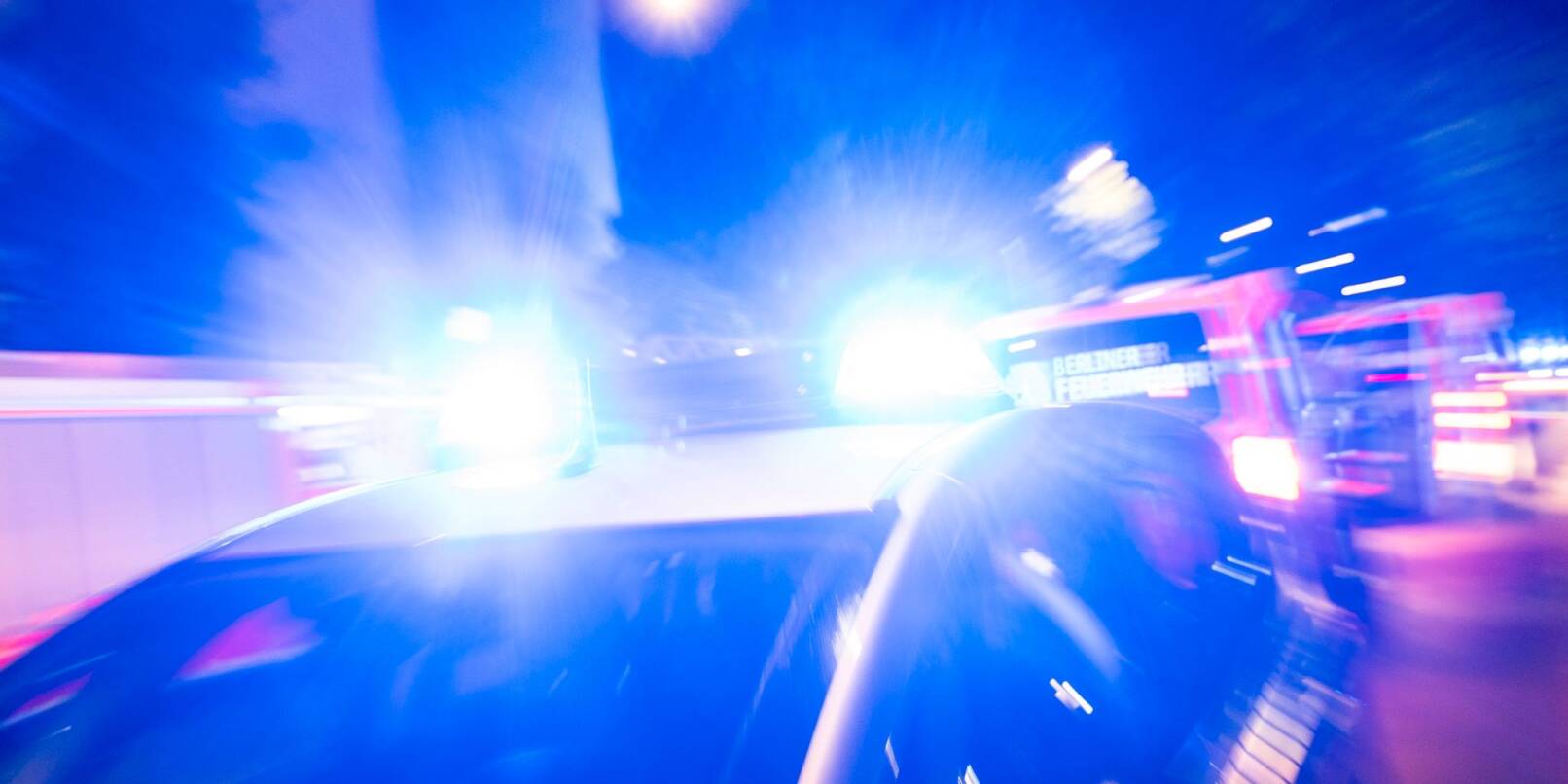 Ein Streifenwagen der Polizei steht mit Blaulicht an einem Einsatzort.