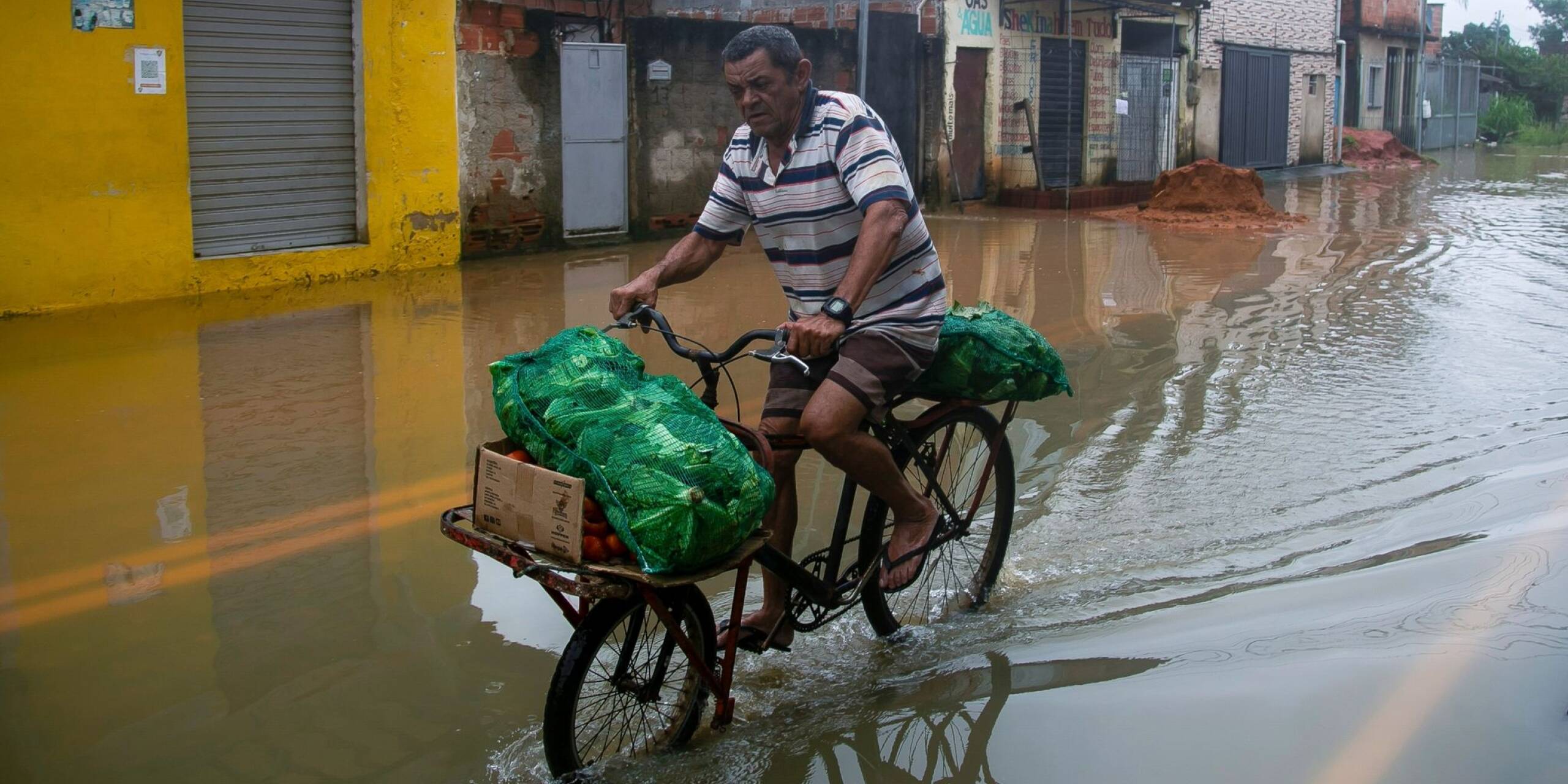 Mit Kraft voran: Durch überflutete Straßen kämpft sich ein Mann auf seinem Fahrrad. Seit der Nacht zu Samstag verwüsteten schwere Unwetter und starke Regenfälle den Südosten Brasiliens, mindestens 23 Personen kamen ums Leben.
