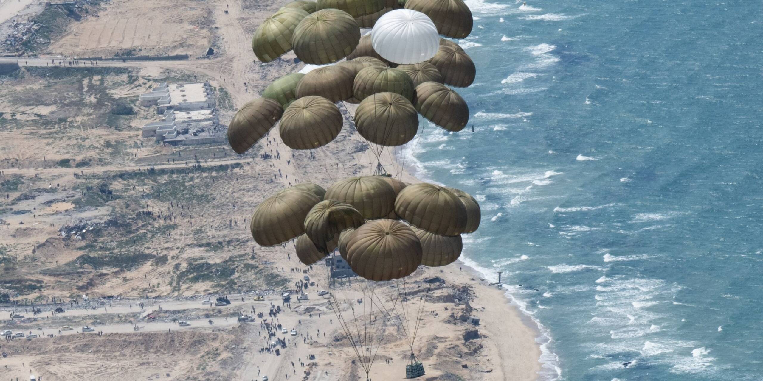 Hilfe aus der Luft: Fallschirme mit Lebensmitteln schweben nach dem Abwurf aus einer Transportmaschine der deutschen Luftwaffe über dem Gazastreifen.