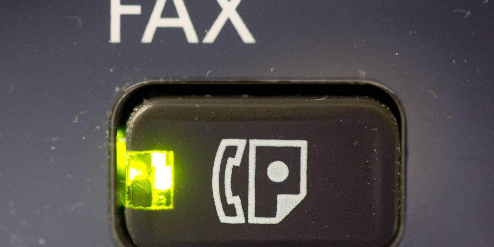 Das Licht an dem Knopf eines Fax-Gerätes leuchtet.