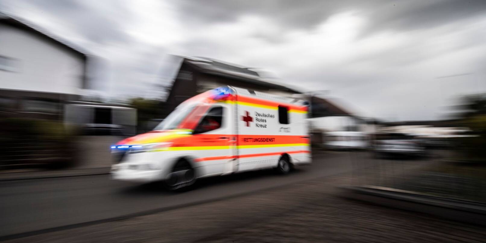 Ein Rettungswagen fährt über die Straße. Ein Rettungswagen fährt über die Straße.