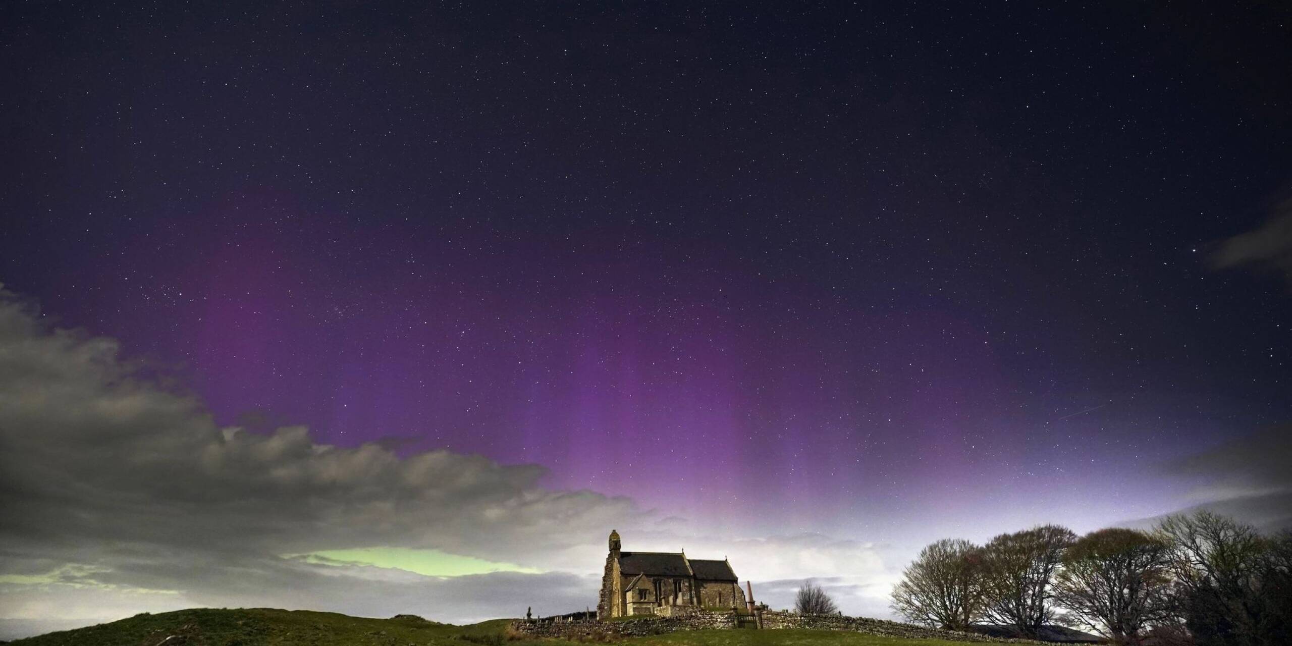 Ein erhabenes Schauspiel: Das Polarlicht, auch bekannt als Nordlicht, erhellt den Himmel kurz vor Mitternacht über der St. Aidan's Church im britischen Dorf Thockrington.