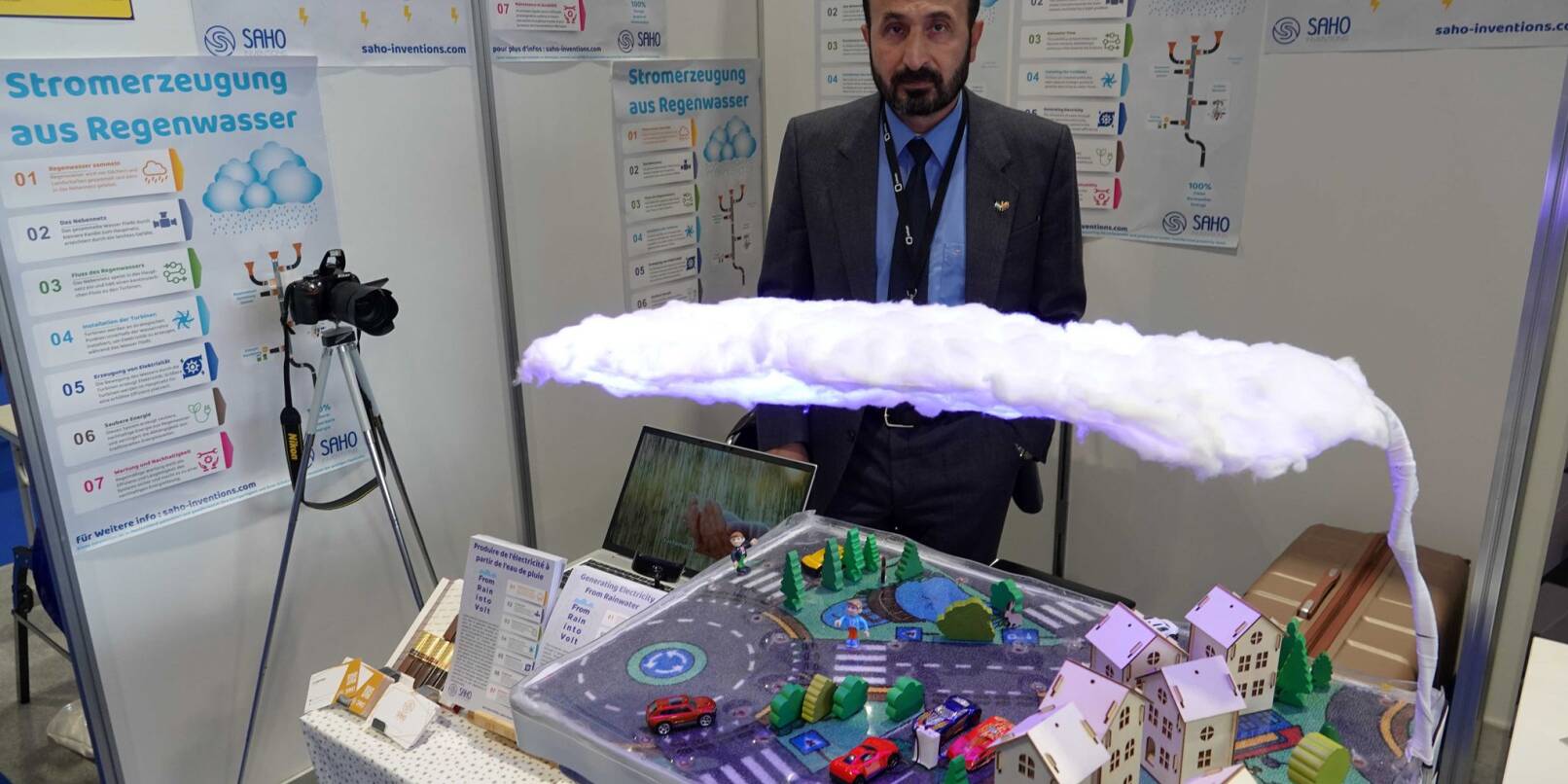 Khaled Al-Saho steht hinter seinem Modell, das die Produktion von Energie aus Regenwasser erklärt.