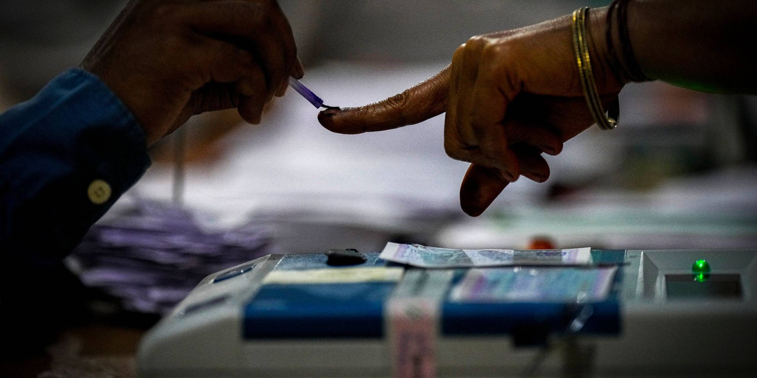 Ein Wahlhelfer markiert den Zeigefinger einer Frau mit unauslöschlicher Tinte, als sie während der indischen Parlamentswahlen im Dorf Bahona im nordöstlichen Assam zur Stimmabgabe erscheint.