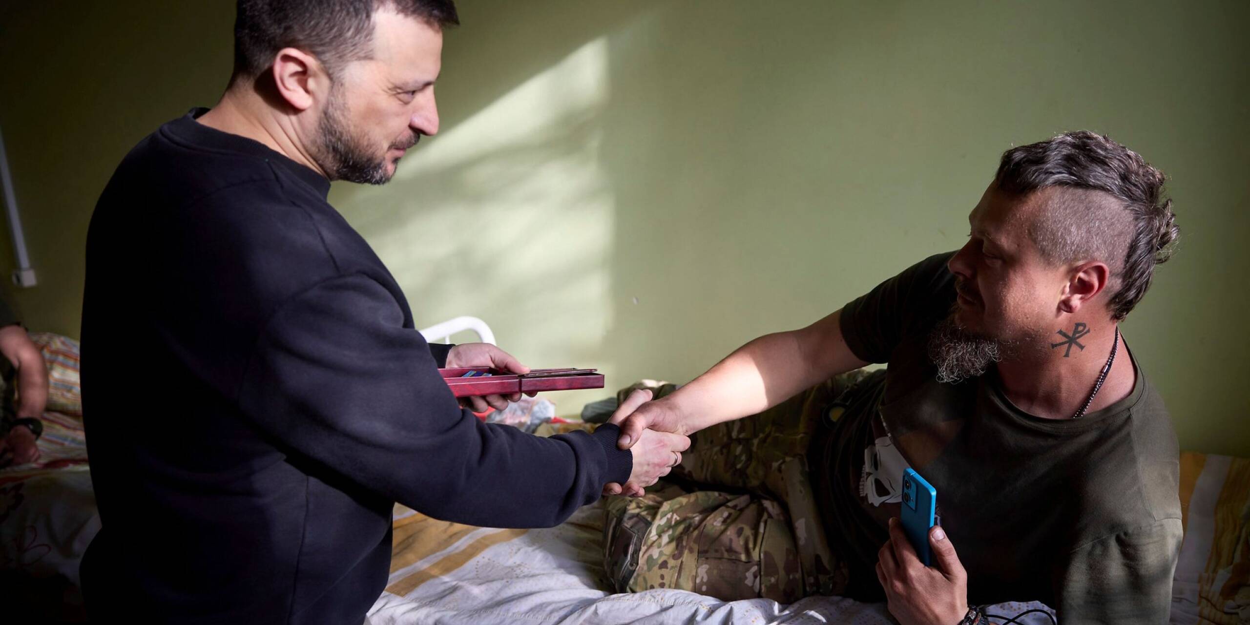Der ukrainische Präsident Wolodymyr Selenskyj verleiht einem verwundeten Soldaten in einem Militärkrankenhaus bei Slowjansk eine Staatsmedaille.