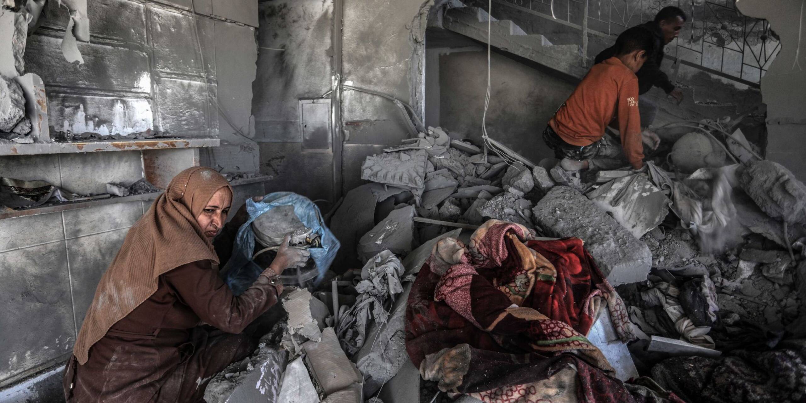 Nach einem israelischen Luftangriff such Palästinenser in einem zerstörten Haus nach Habseligkeiten.