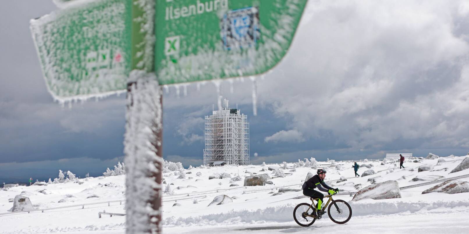 Ein Radfahrer ist auf dem schneebedeckten Brocken unterwegs.