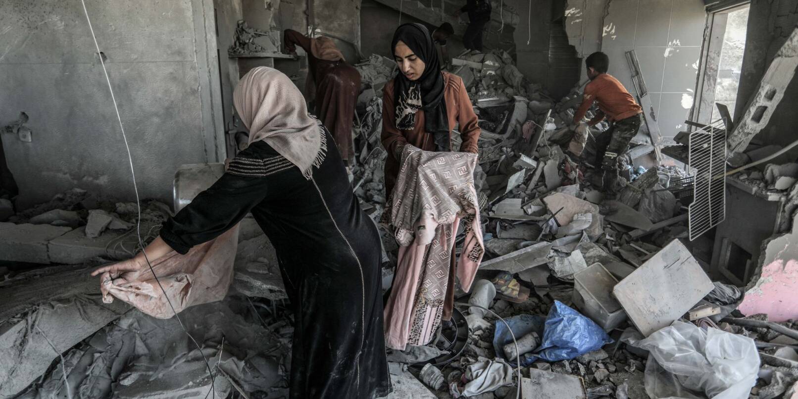 Palästinenserinnen suchen in einem zerstörten Haus in Rafah nach Habseligkeiten.