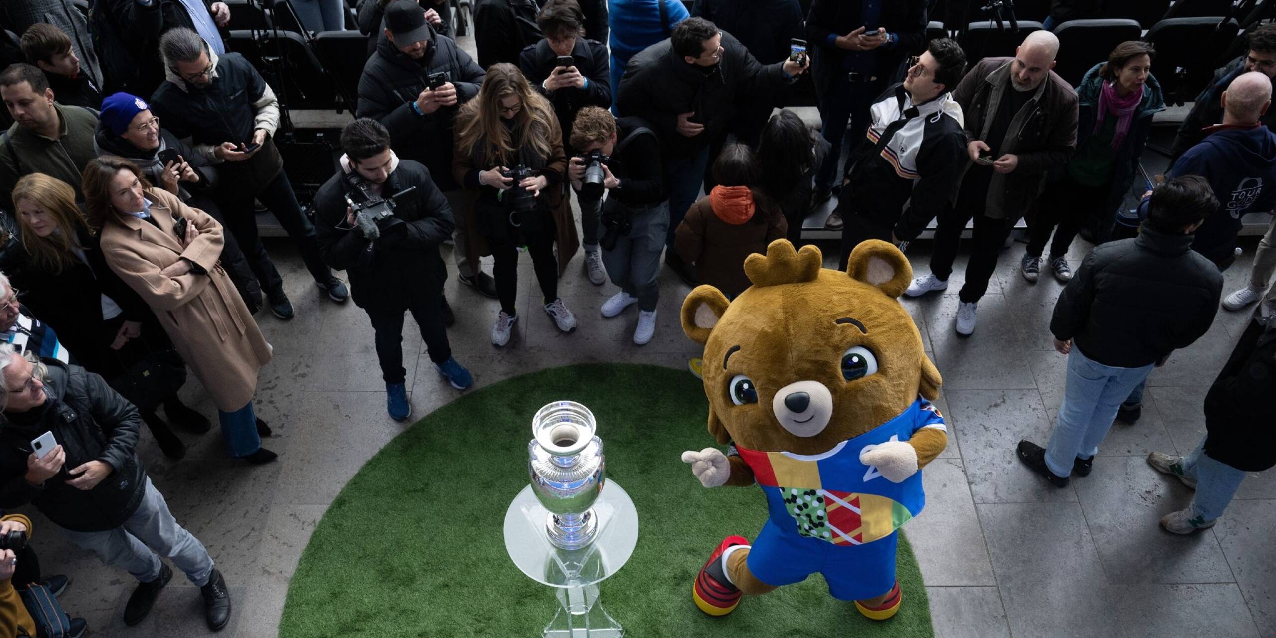 Umringt von Fotografen präsentiert Maskottchen Albärt den EM-Pokal im Berliner Olympiastadion.