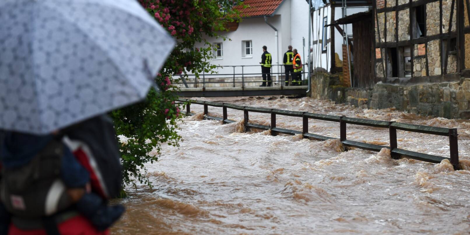Feuerwehrleute beobachten die über die Ufer getretene Losse. Schwere Regenfälle hatten seinerzeit zahlreiche Bäche in Nordhessen zum Überlaufen gebracht.