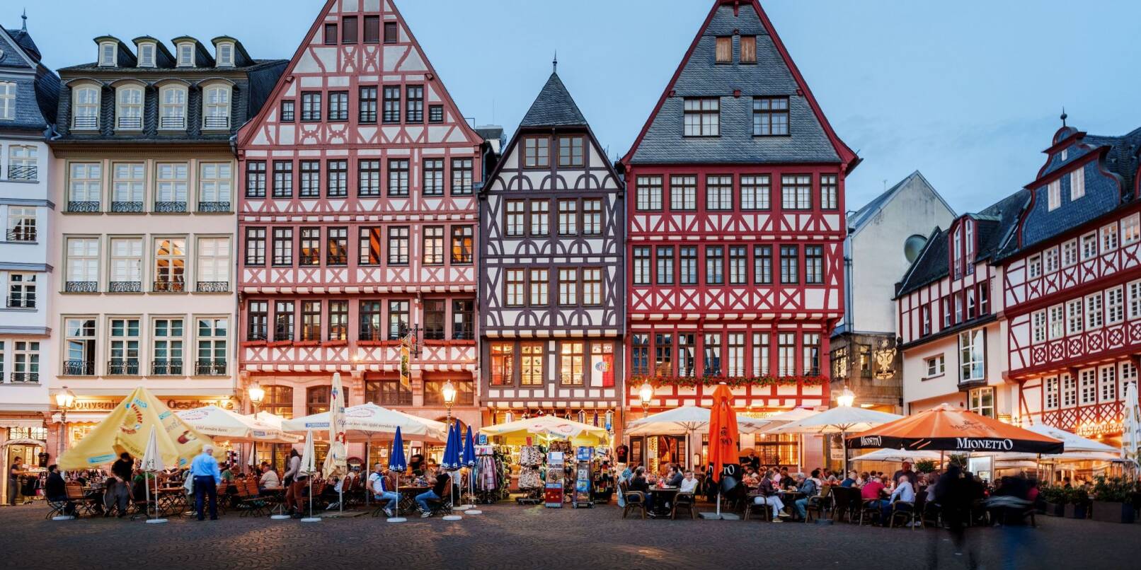 Menschen sitzen in der Außengastronomie auf dem Römerberg. Die Nachfrage ist da, aber die Gewinne steigen kaum - am Ende des Sommers sind Gastronomen und Hoteliers in Hessen halbwegs zufrieden, aber nicht glücklich.