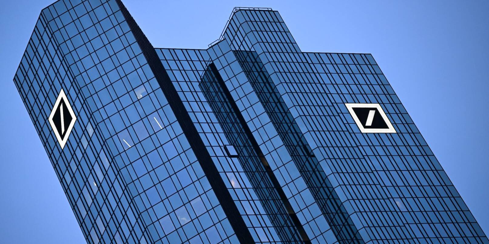 Das Logo der Deutschen Bank leuchtet an der Fassade der Unternehmenszentrale.