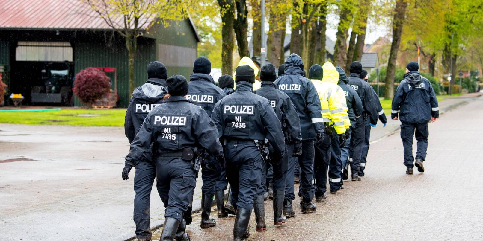 Polizisten gehen auf der Suche nach einem vermissten Jungen durch eine Ortschaft in Niedersachsen.