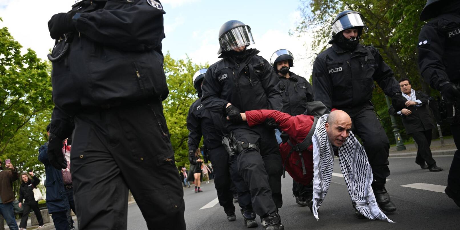 Polizeibeamte nehmen einen Teilnehmer einer Unterstützungsversammlung für das propalästinensische Protestcamp mit.