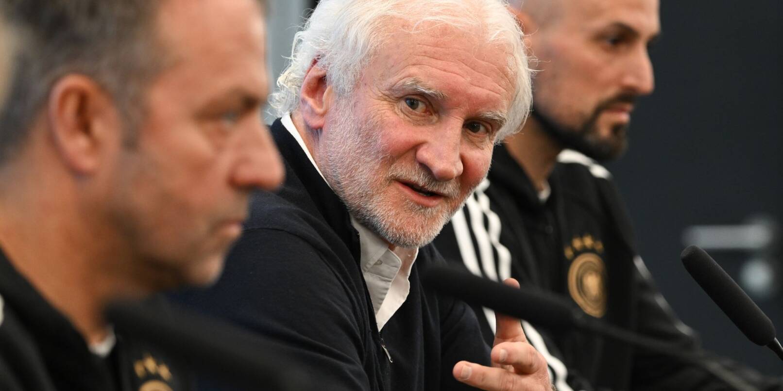 DFB-Sportdirektor Rudi Völler (M.) setzte sich bewusst zwischen Bundestrainer Hansi Flick (l) und U21-Coach Antonio Di Salvo.
