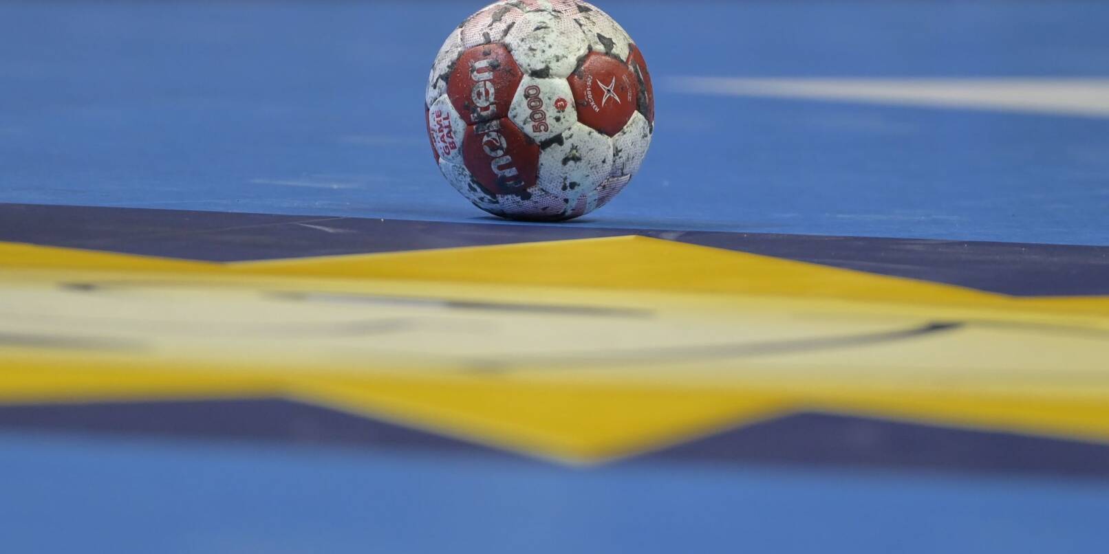 Ein Spielball liegt auf einem Handballfeld.
