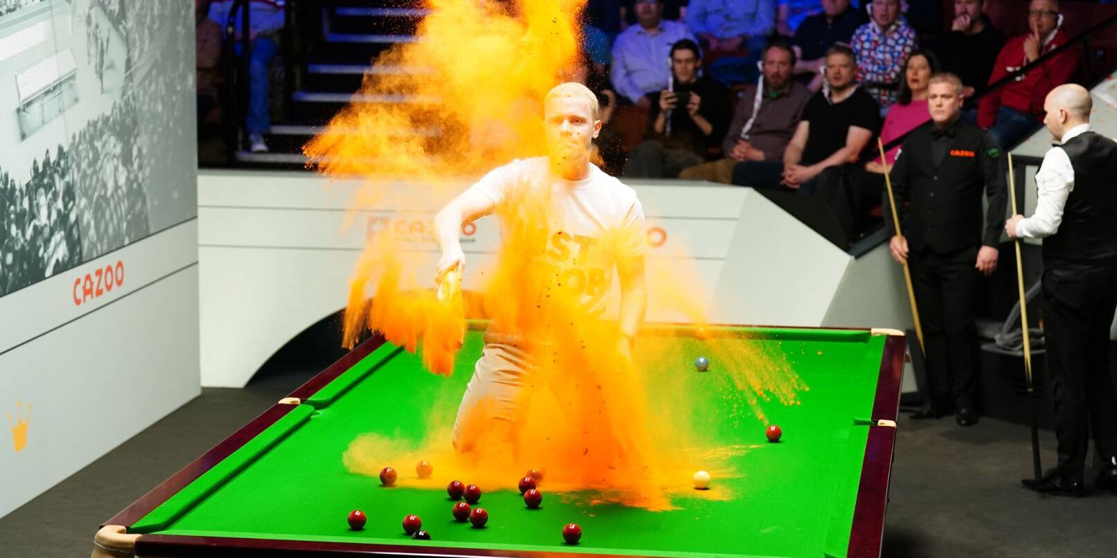 Ein «Just Stop Oil»-Demonstrant springt während der Snooker-WM auf den Tisch und wirft orangenes Pulver. Die Partie zwischen Robert Milkins und Joe Perry wurde unterbrochen und der Tisch mit einem Staubsauger gereinigt.