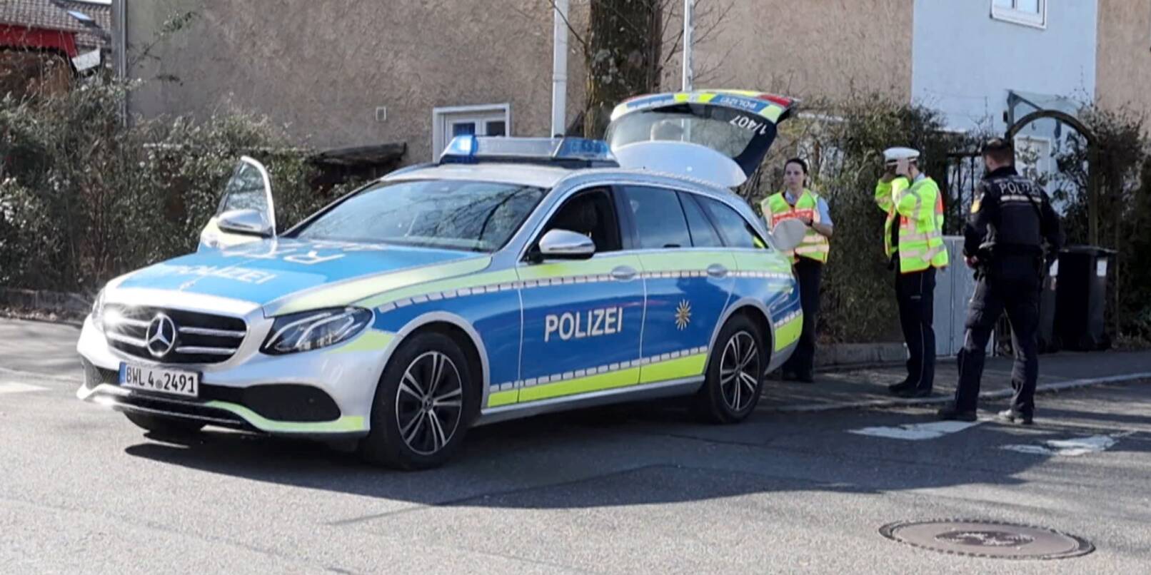 Einsatzkräfte der Polizei stehen an Einsatzfahrzeugen in Reutlingen.