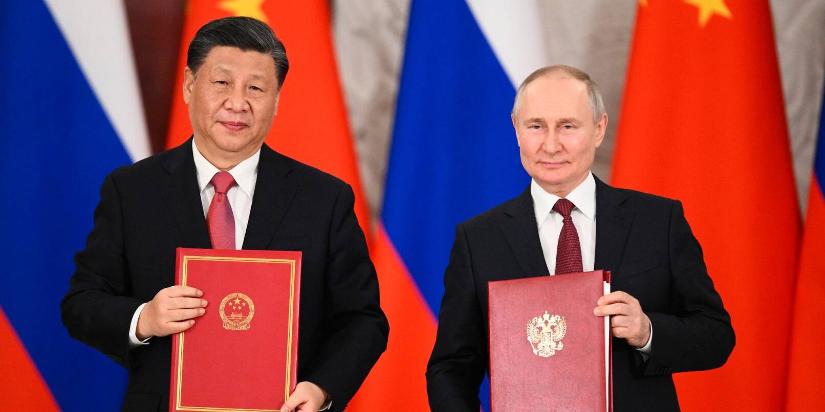Chinas Präsident Xi Jinping und sein russischer Amtskollege Wladimir Putin zeigen während einer Unterzeichnungszeremonie Mappen mit den neuen Abkommen.