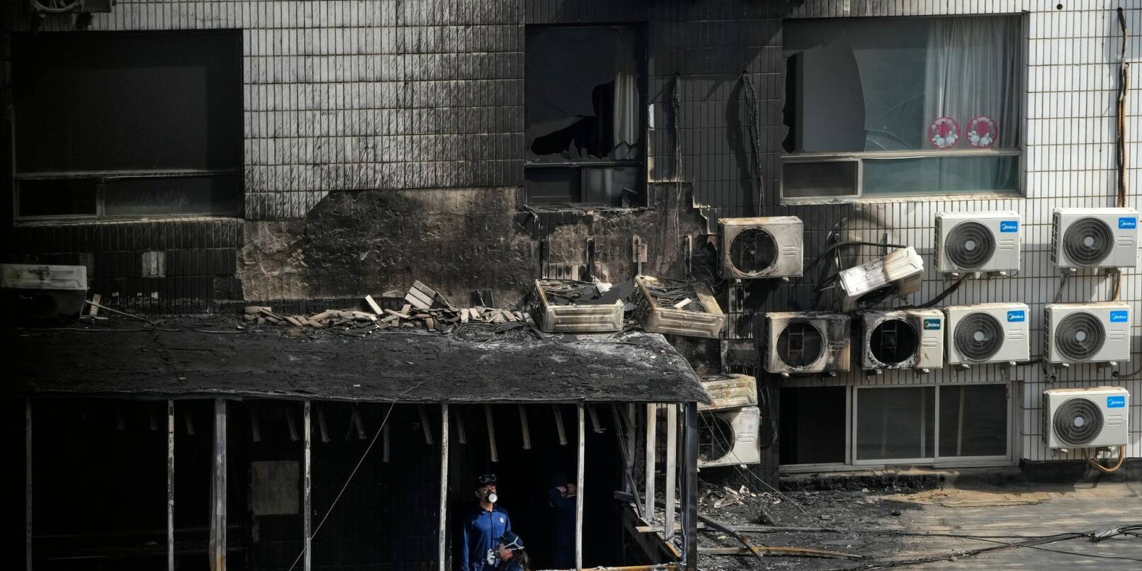 Ermittler inspizieren einen ausgebrannten Korridor nach dem Brand in dem Krankenhaus in Peking.