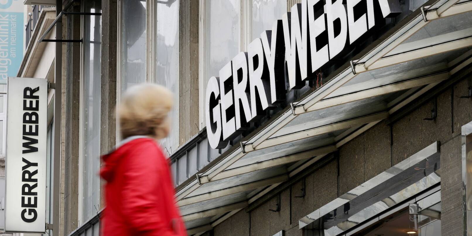 Eine Passantin vor einer Filiale des Modeherstellers Gerry Weber in Köln: Der Modeherstaeeler will zurück aus Kurs.