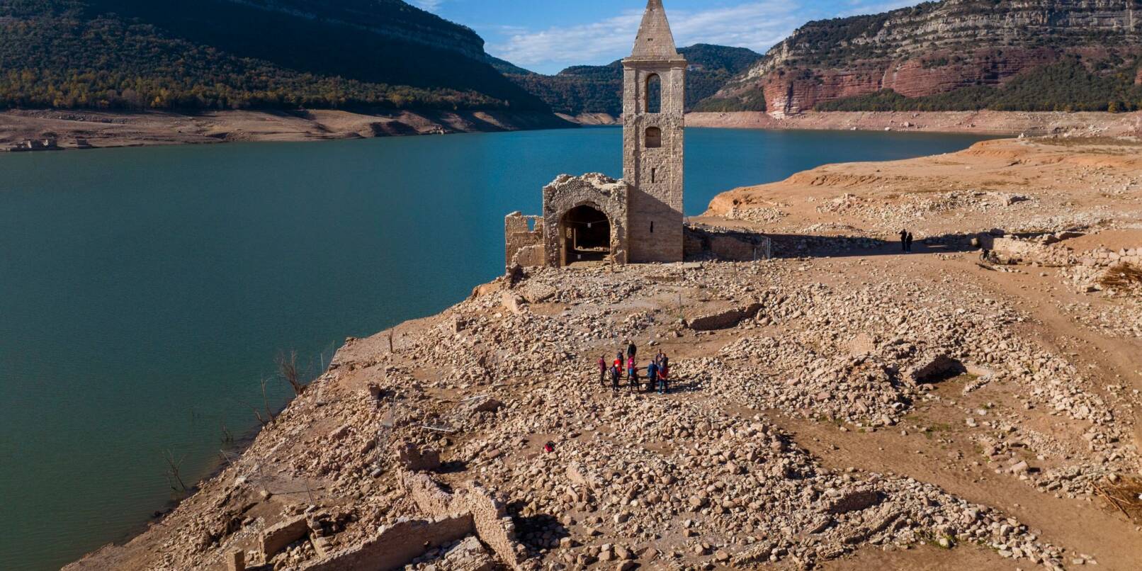 Eine Kirche und die Überreste eines alten Dorfes, die normalerweise vom Wasser bedeckt werden, sind am Stausee von Sau in Katalonien zu sehen. Eine Kirche und die Überreste eines alten Dorfes, die normalerweise vom Wasser bedeckt werden, sind am Stausee von Sau in Katalonien zu sehen.