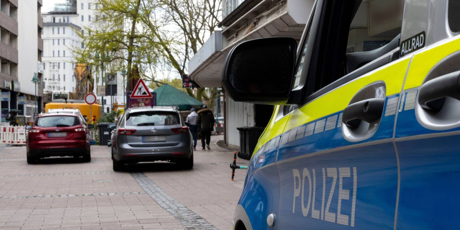 Fahrzeuge der Polizei stehen in Duisburg vor dem Wohnhaus des Tatverdächtigen.