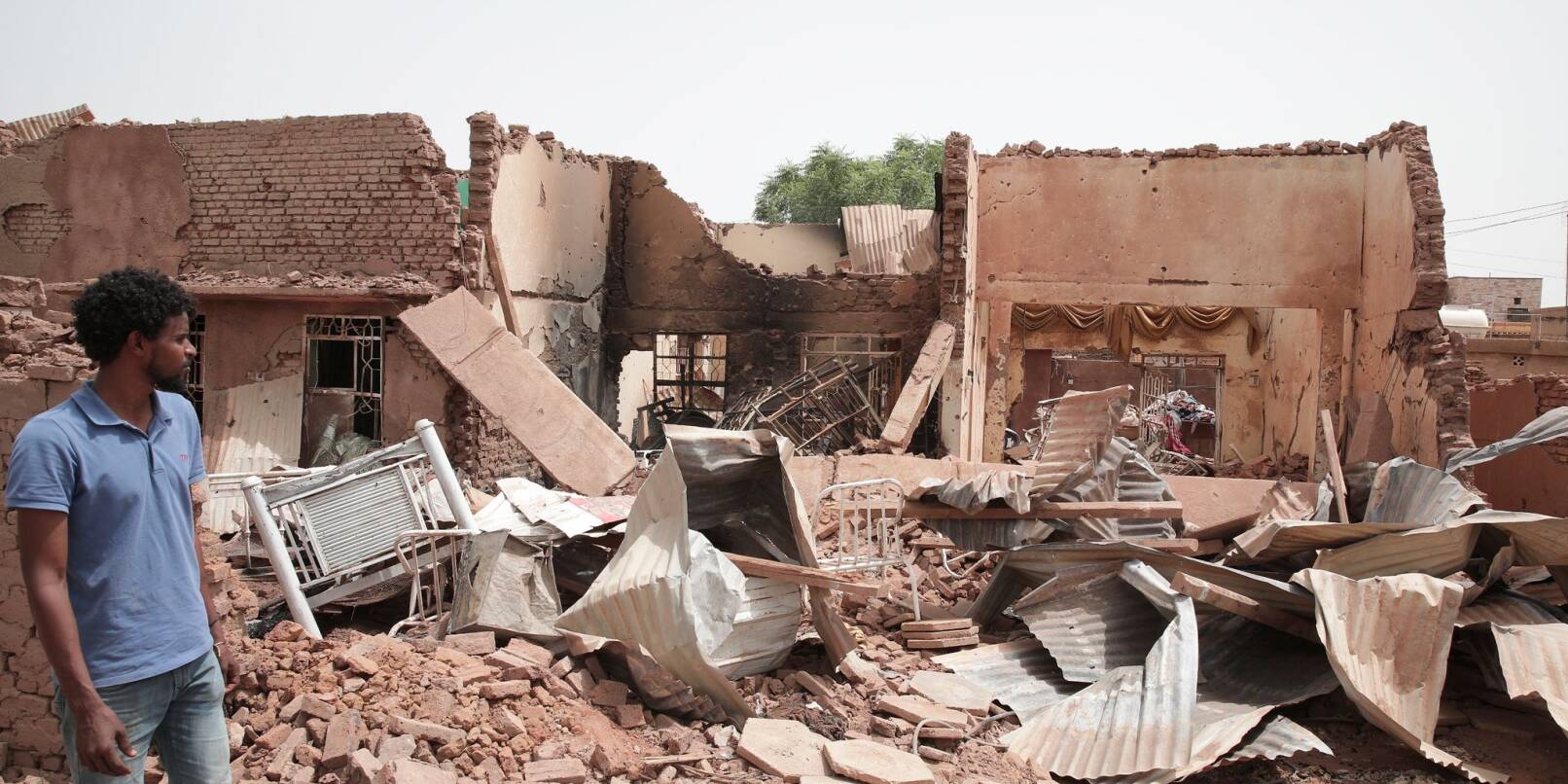Ein Mann geht an einem Haus in Khartum vorbei, das bei den jüngsten Kämpfen im Sudan getroffen wurde.