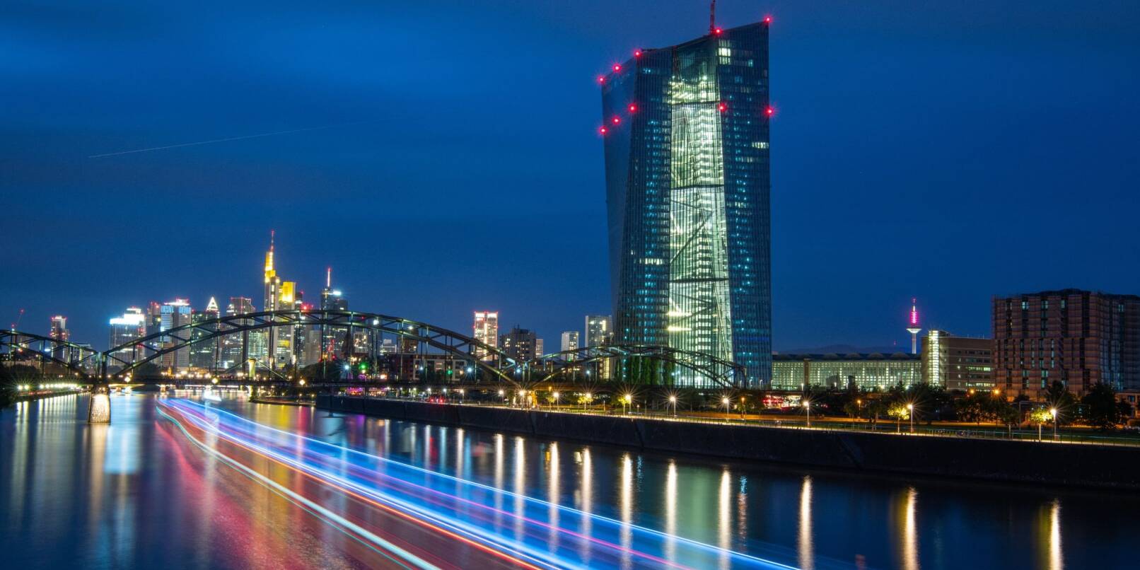 Lichter der Frankfurter Bankenskyline und der Europäischen Zentralbank (EZB) leuchten am Abend.