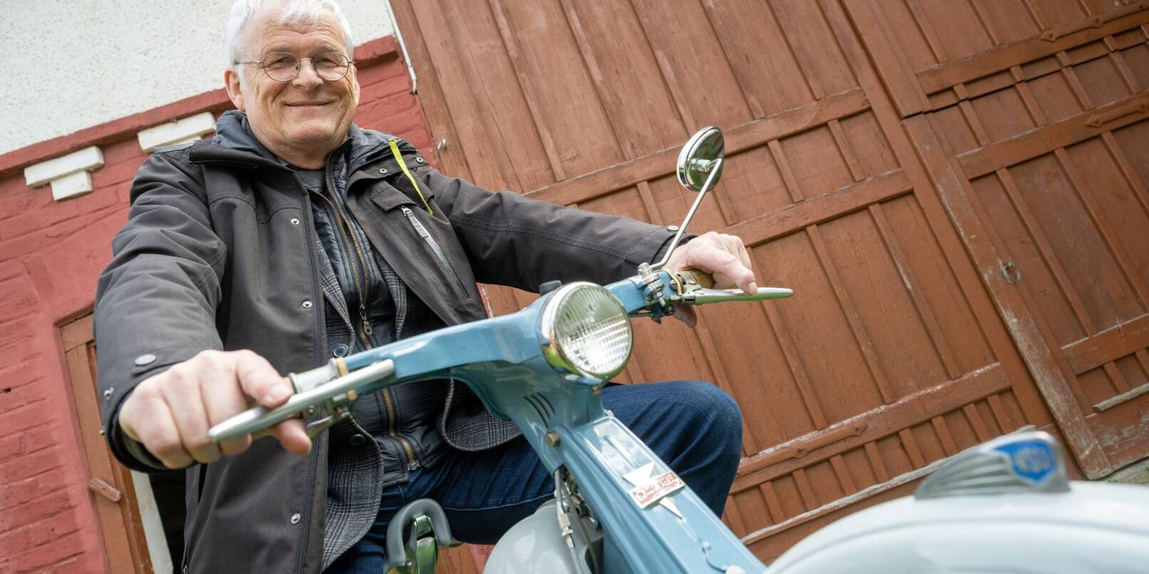 Elmar Braun sitzt auf einem Motorrad vom Typ NSU Quickly.