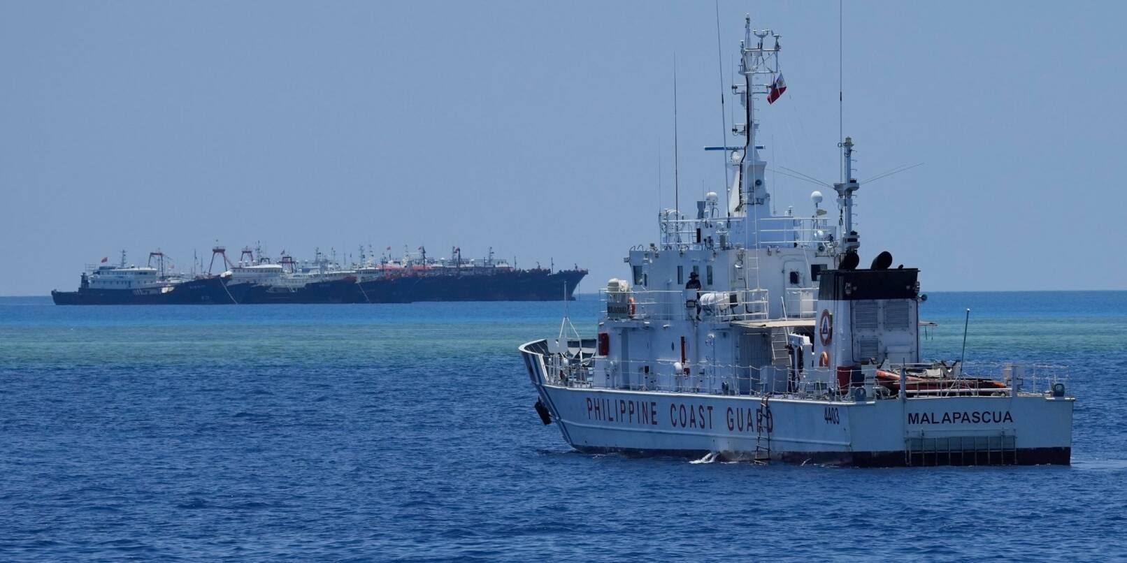 Ein Schiff der philippinischen Küstenwache nähert sich einigen der vielen mutmaßlichen chinesischen Milizschiffe an dem von den Philippinen beanspruchten Riff namens Whitsun.