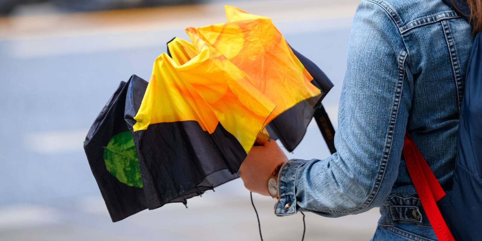 Eine Frau hält einen Regenschirm in der Hand.