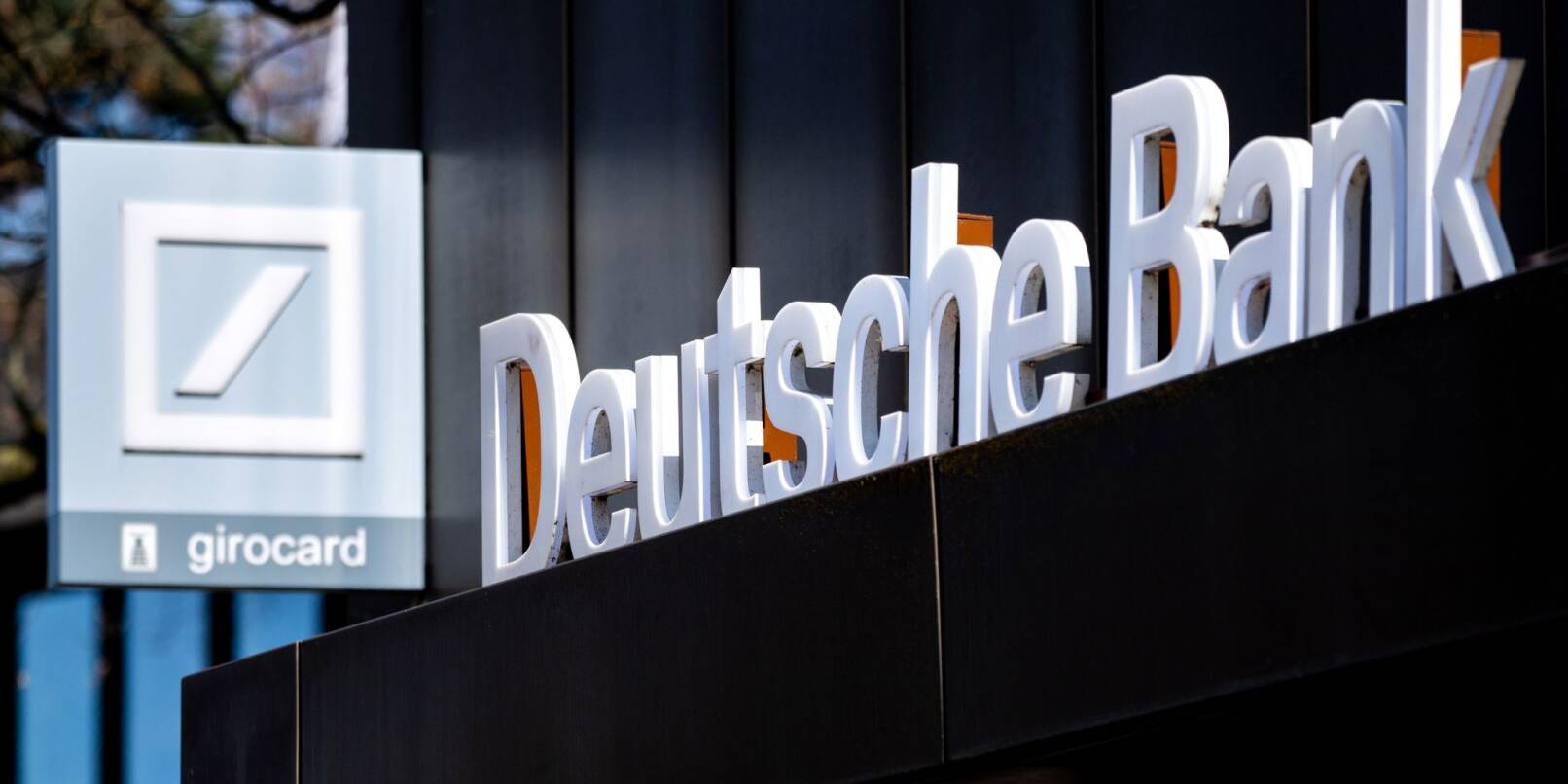Logo und Schriftzug der Deutschen Bank an einer Bankfiliale.