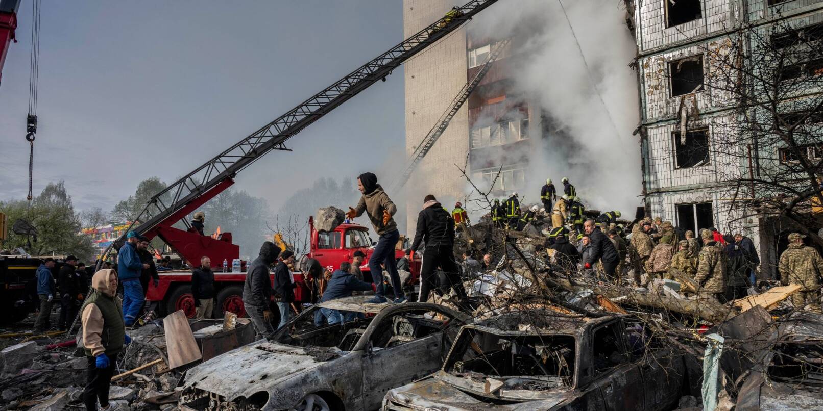 Nach dem russischen Angriff beseitigen Rettungskräfte die Trümmer eines Wohnhauses in Uman.
