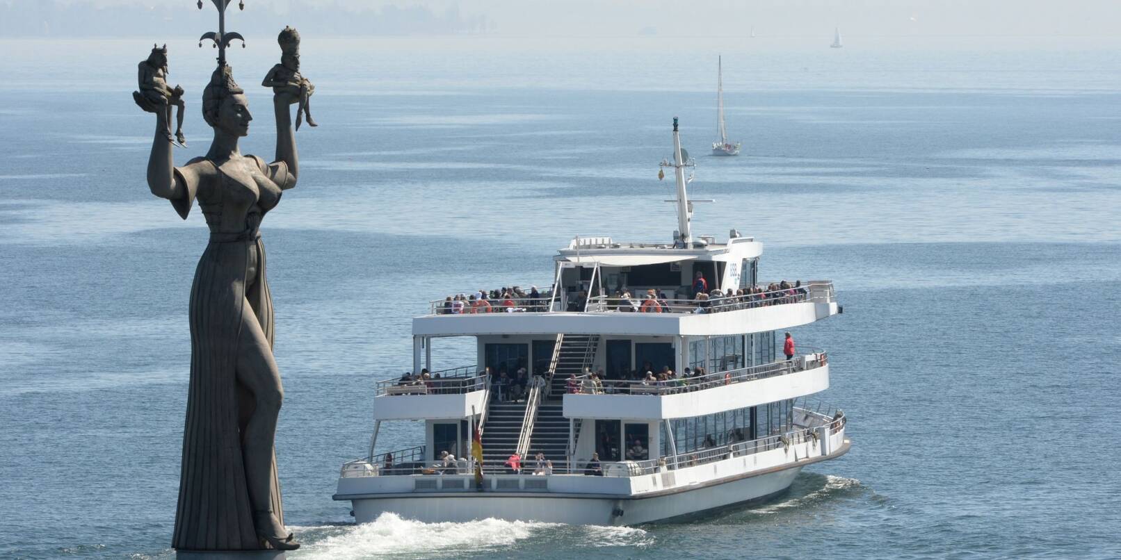 Ein Passagierschiff fährt auf dem Bodensee aus dem Hafen von Konstanz, während sich die «Imperia», eines der Wahrzeichen von Konstanz, an der Hafeneinfahrt dreht.