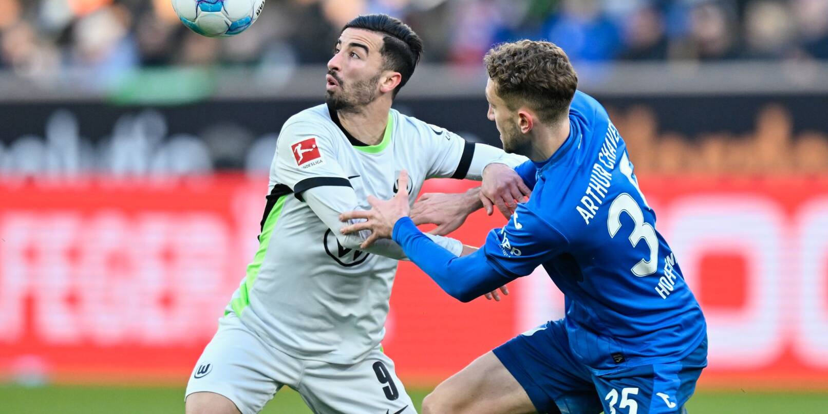 Wolfsburgs Mohamed Amoura (l) und Hoffenheims Arthur Chaves im Zweikampf. Wolfsburgs Mohamed Amoura (l) und Hoffenheims Arthur Chaves im Zweikampf.
