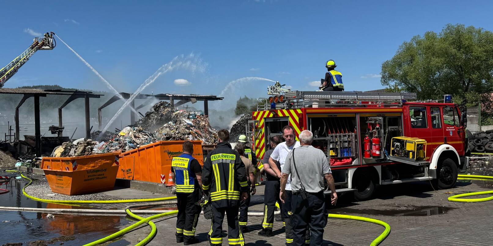 Feuerwehrleute löschen einen Brand in einem Entsorgungsbetrieb. Feuerwehrleute löschen einen Brand in einem Entsorgungsbetrieb.