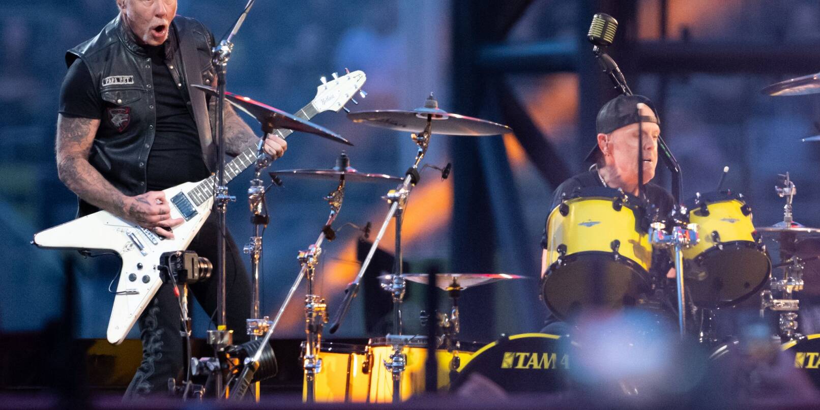 James Hetfield (l), Sänger und Gitarrist, und Lars Ulrich, Schlagzeuger, von der US-Metal-Band Metallica stehen im Münchner Olympiastadion auf der Bühne. James Hetfield (l), Sänger und Gitarrist, und Lars Ulrich, Schlagzeuger, von der US-Metal-Band Metallica stehen im Münchner Olympiastadion auf der Bühne.