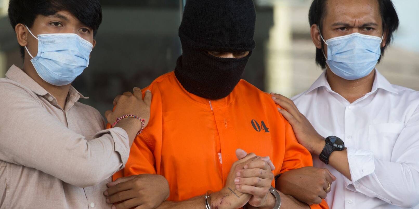 Der Verdächtige wurde in einem orangen Sträflingsanzug der Presse vorgeführt. Der Verdächtige wurde in einem orangen Sträflingsanzug der Presse vorgeführt.