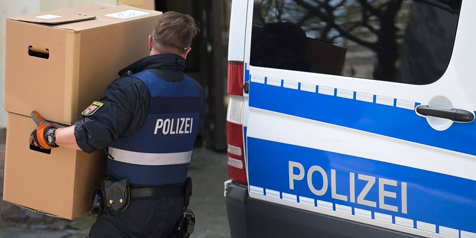 Ein Polizeibeamter entlädt am Landeskriminalamt Rheinland-Pfalz einen Transporter mit sichergestelltem Material aus einer Razzia in mehreren Bundesländern gegen die italienische Mafia 'Ndrangheta.
