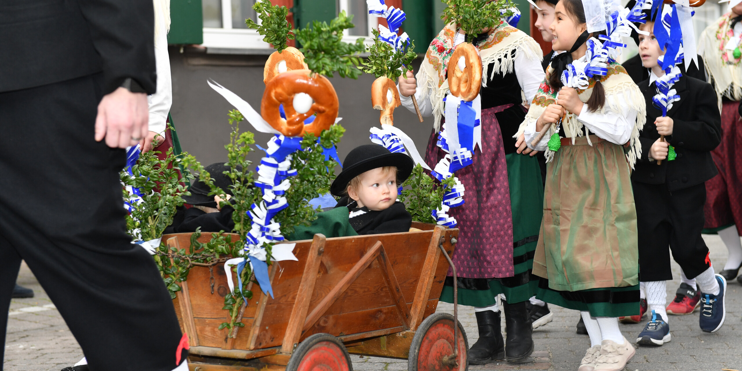 Kinder sitzen beim Weinheimer Sommertagszug in einem Leiterwagen. Kinder sitzen beim Weinheimer Sommertagszug in einem Leiterwagen.