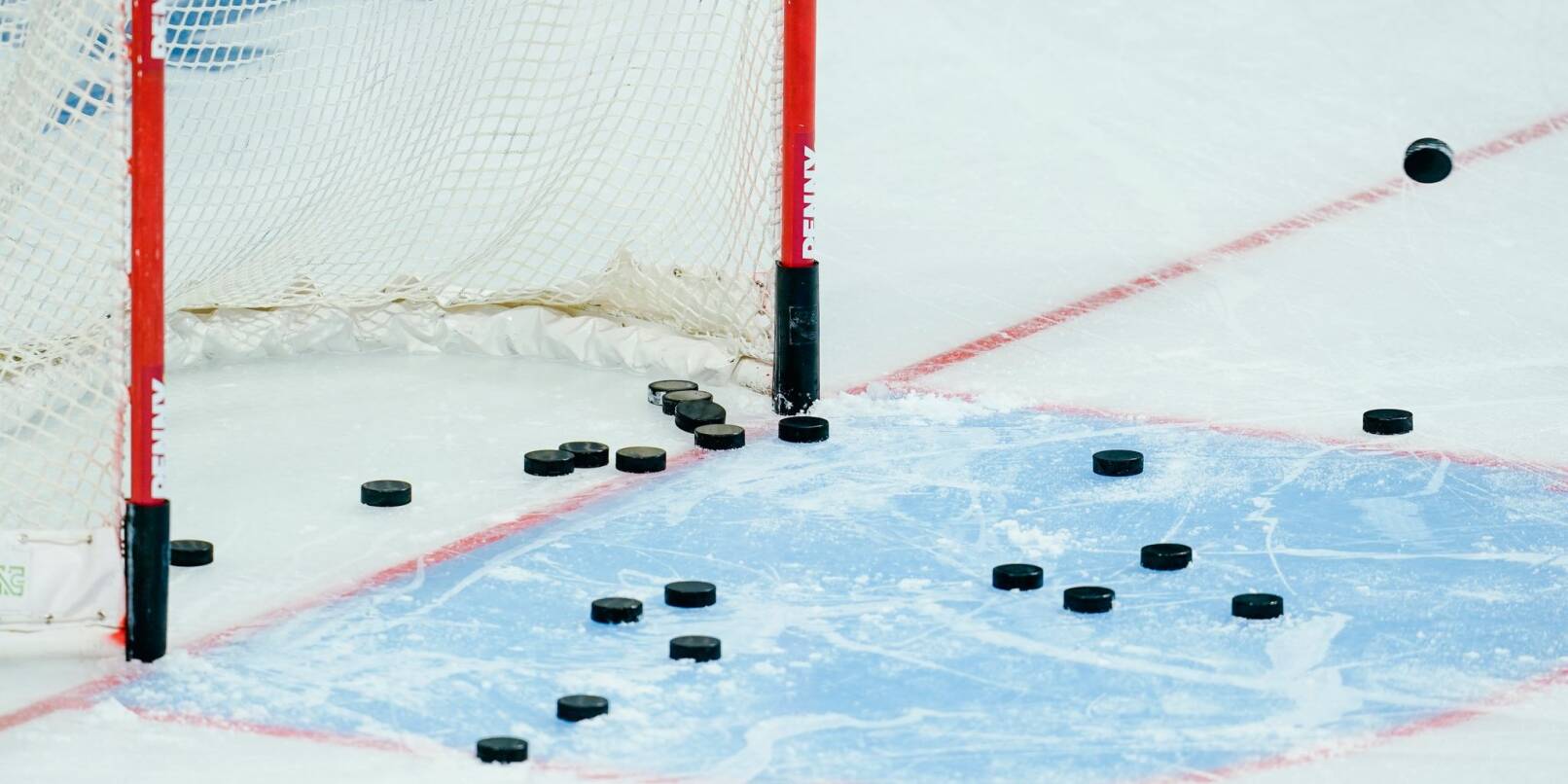 Eishockey-Pucks liegen im Torraum. Eishockey-Pucks liegen im Torraum.