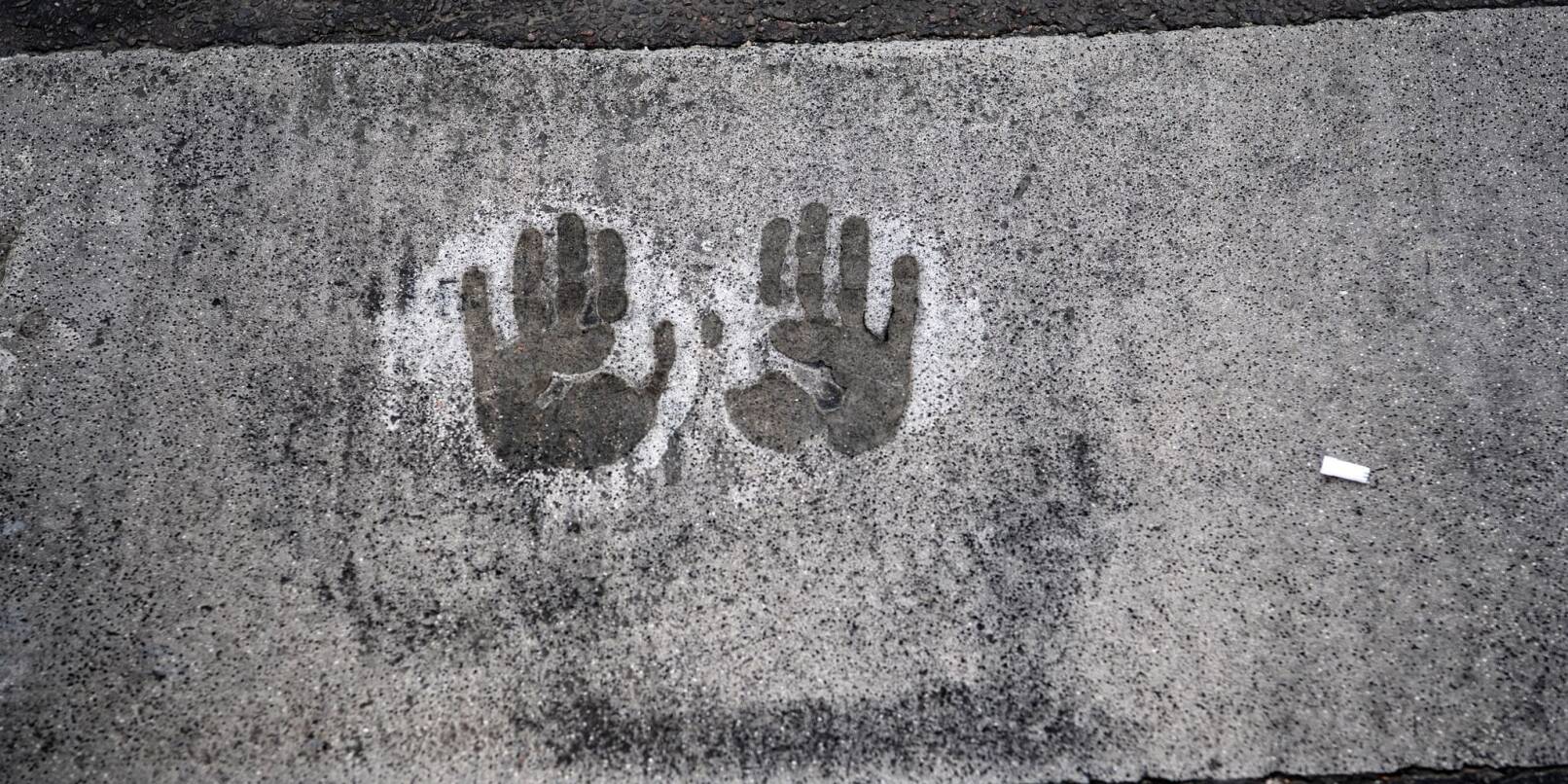 Der Abdruck von zwei Händen bei einer Straßenblockade der Letzten Generation in Berlin.