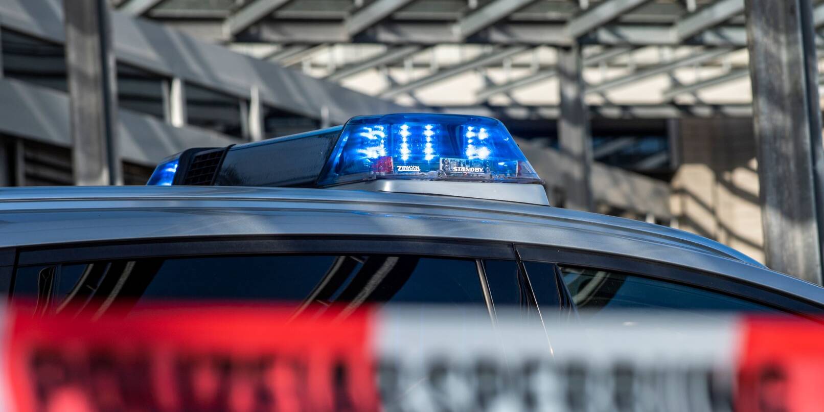 Ein Polizei-Blaulicht leuchtet über einem Absperrband mit der Aufschrift «Polizeiabsperrung».